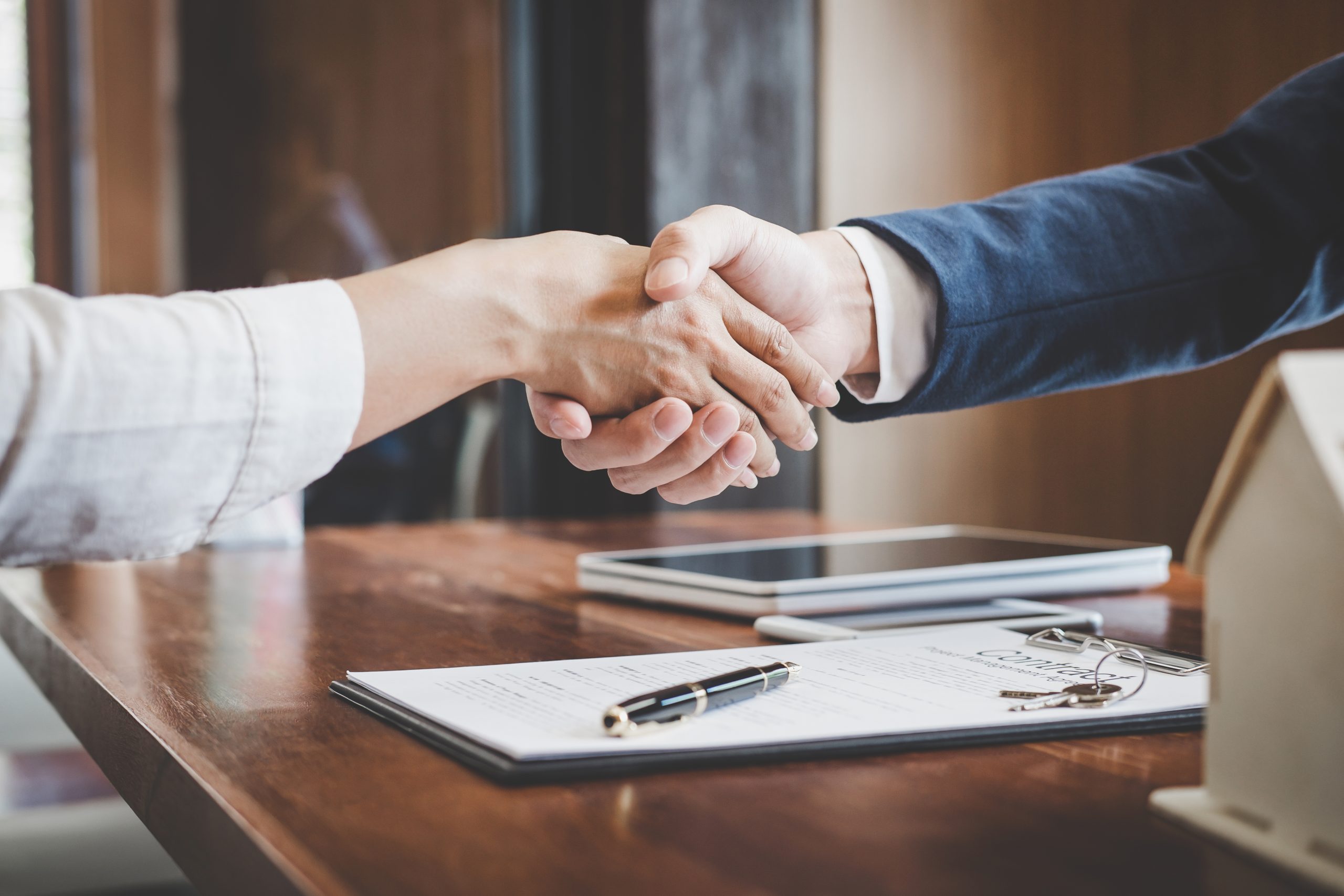 Real,Estate,Agent,And,Customers,Shaking,Hands,Together,Celebrating,Finished