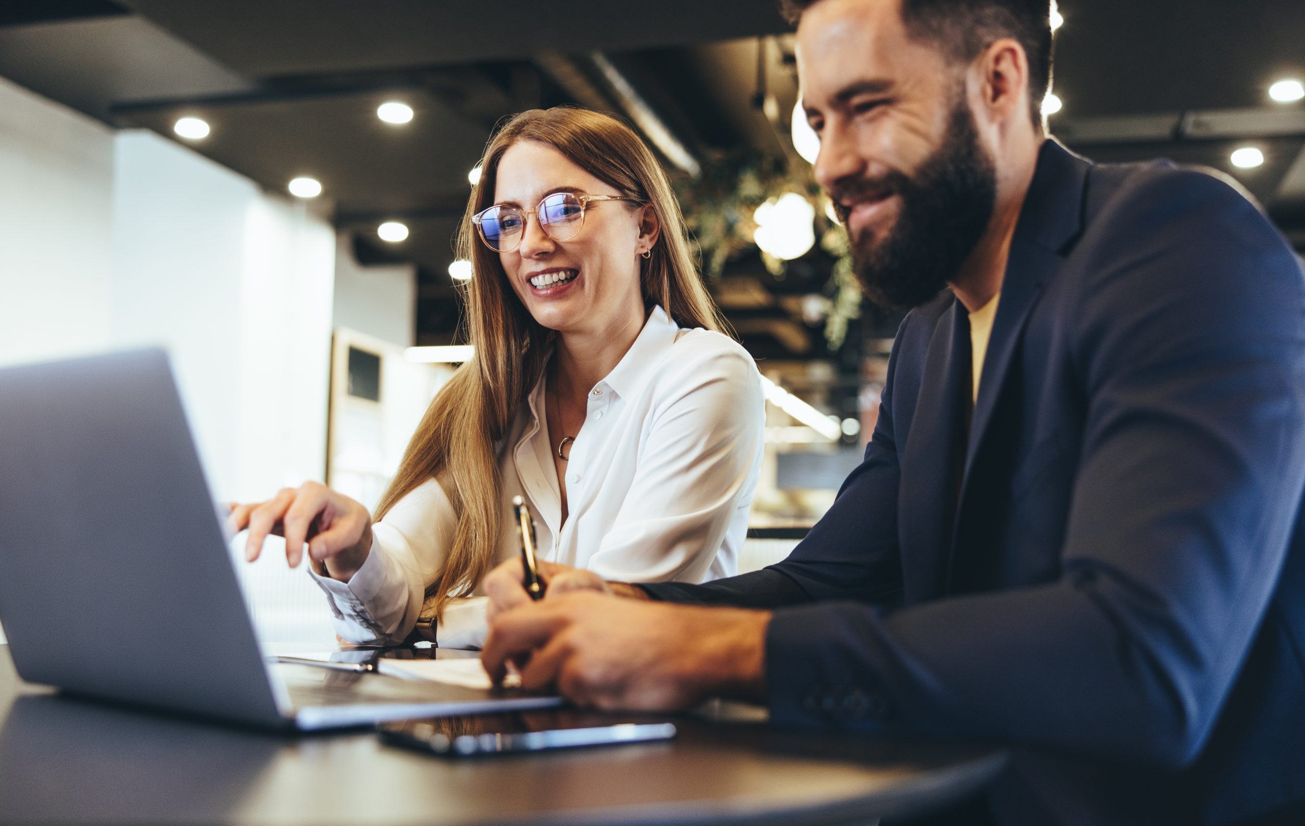 Cheerful,Businesspeople,Using,A,Laptop,In,An,Office.,Happy,Young